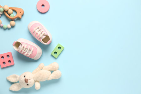Stylish baby shoes with toys on blue backgroundの写真素材