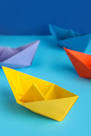 Colorful origami boats on color backgroundの写真素材