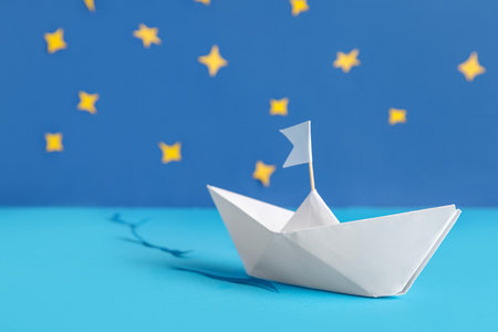 White origami boat with flag and decor on color backgroundの写真素材