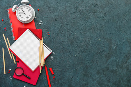 Composition with different stationery and alarm clock on dark color backgroundの写真素材