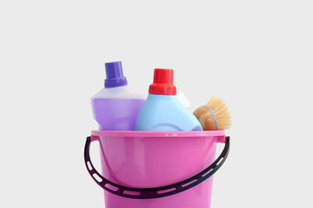 Plastic bucket with cleaning supplies on white backgroundの写真素材