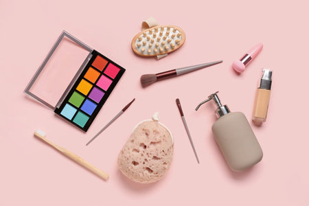 Composition with bath supplies and decorative cosmetics on pink background