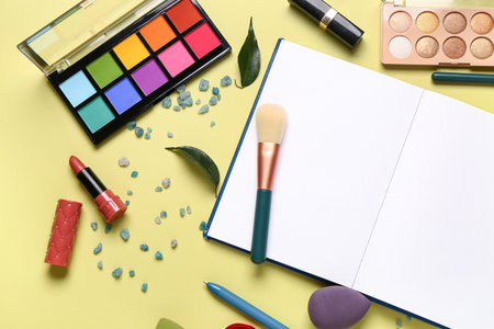Composition with makeup cosmetics, sea salt and notebook on yellow backgroundの写真素材