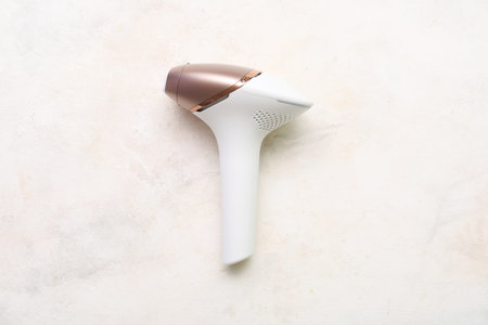 Modern photoepilator on grunge white background