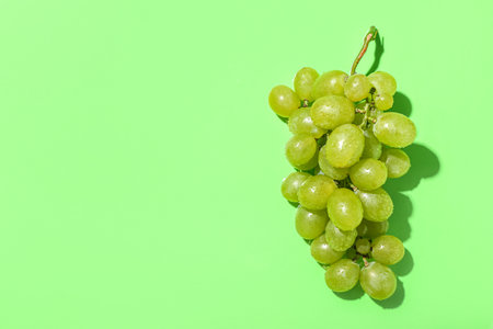 Sweet green grapes on color backgroundの写真素材