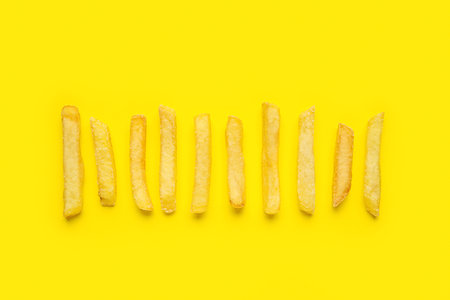Tasty French fries on yellow backgroundの写真素材