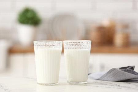 Glasses of fresh milk on white tableの写真素材