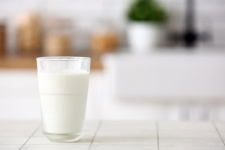 Glass of fresh milk on white tile tableの写真素材