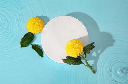 Composition with blank paper sheet and beautiful chrysanthemum flowers in water on blue background