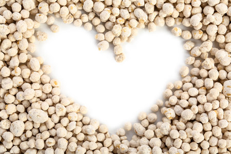 Granular fertilizer in the shape of heart on white backgroundの写真素材