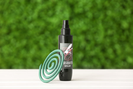 Spray bottle of mosquito repellent and coil on table outdoorsの写真素材