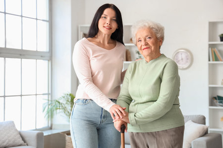 Senior woman with walking stick and her daughter at home