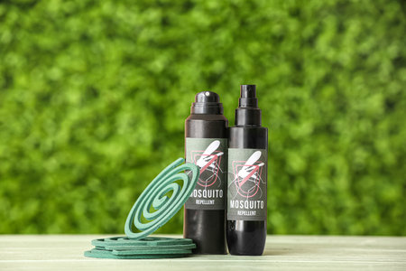 Spray bottles and coils of mosquito repellent on table outdoorsの写真素材