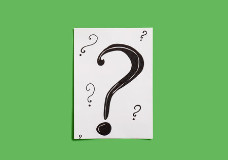 Paper with question marks on green backgroundの写真素材