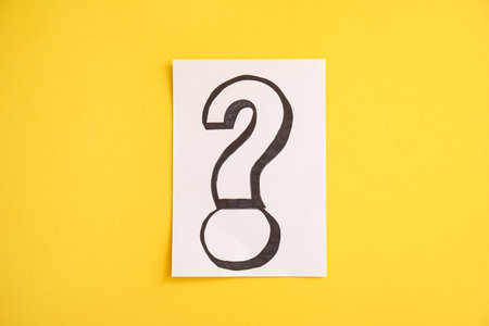 Paper with question mark on yellow backgroundの写真素材