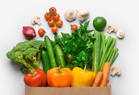 Paper bag with fresh vegetables, fruits and mushrooms on white backgroundの写真素材