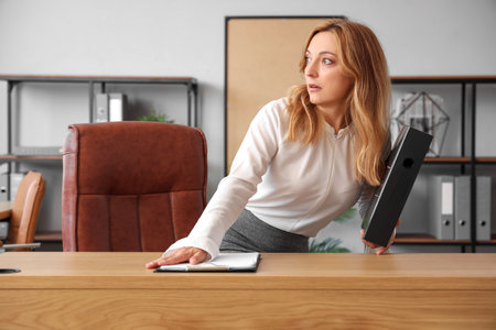 Scared mature businesswoman in officeの写真素材
