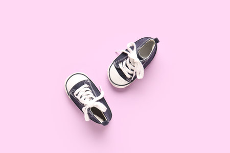 Stylish baby shoes on purple background