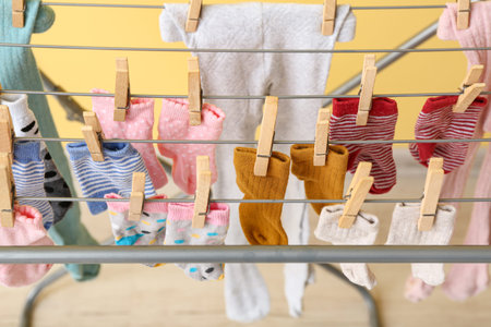 Clean baby clothes hanging on dryer, closeupの写真素材