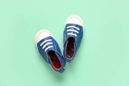 Stylish baby shoes on turquoise backgroundの写真素材