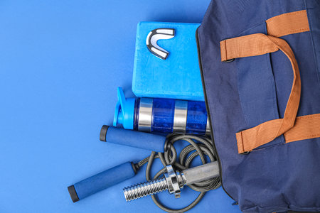 Sport bag with skipping rope and bottle of water on blue backgroundの写真素材