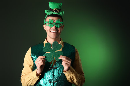 Young man with clover on dark green background. St. Patrick's Dayの写真素材