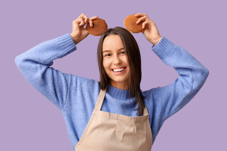 Funny young woman with tasty pancakes on lilac backgroundの写真素材