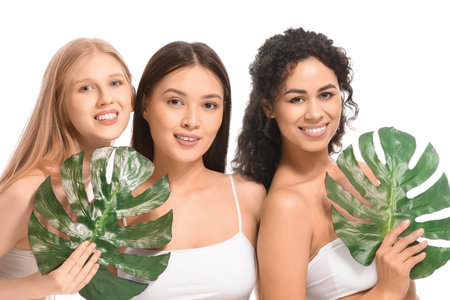 Beautiful young women with palm leaves on white backgroundの写真素材