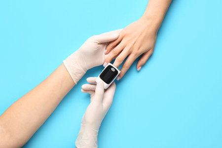 Doctor with pulse oximeter and patient on blue background