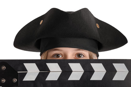 Little actor dressed as pirate with movie clapper on white background, closeup