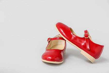 Pair of red child's shoes on gray backgroundの写真素材