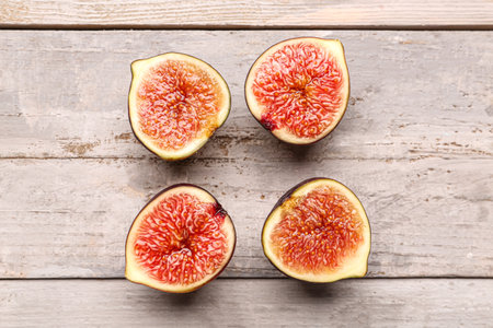 Halves of fresh ripe figs on gray wooden backgroundの写真素材