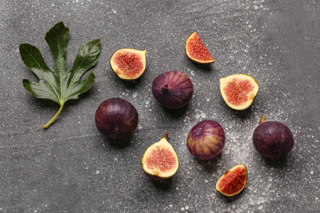 Fresh ripe figs and leaves on gray background