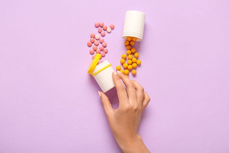 Female hand with jars of different pills on lilac backgroundの写真素材