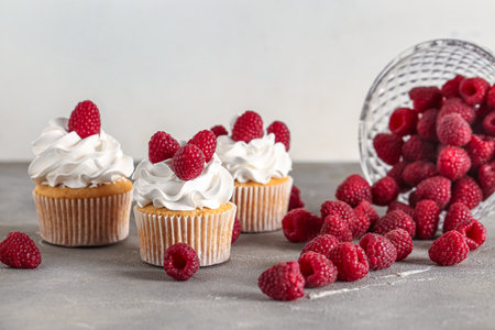 Tasty raspberry cupcakes and fresh berries on tableの写真素材