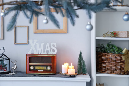 Christmas decor and burning candles on mantelpiece in festive living room, closeupの写真素材