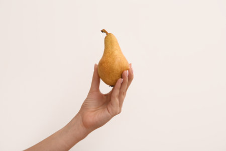 Woman holding ripe pear on white backgroundの写真素材