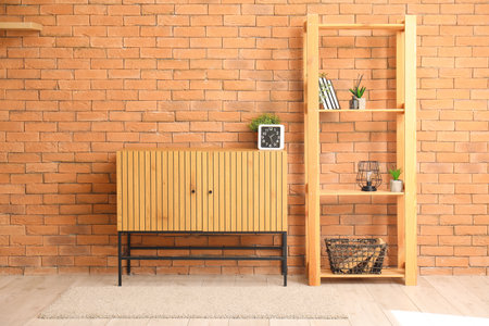 TV stand with clock and shelf unit near brick wall in roomの写真素材