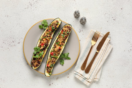 Plate with meat stuffed zucchini boats on light backgroundの写真素材
