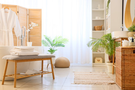 Interior of light bathroom with gray bench and bathtubの写真素材