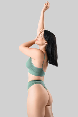 Beautiful woman in underwear on light backgroundの写真素材