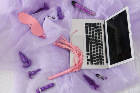 Sex toys with laptop on lilac fabric backgroundの写真素材