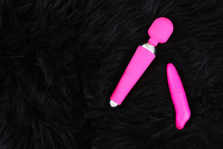 Vibrators on black fur blanket, top viewの写真素材