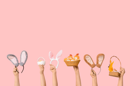 Female hands holding Easter bunny ears headbands with baskets on pink background
