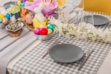 Beautiful table setting with flowers, Easter bunny and painted eggs