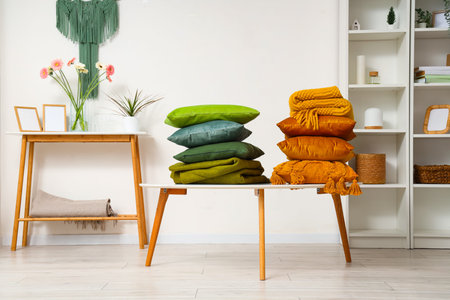 Stack of pillows with folded warm plaids on coffee table in roomの写真素材