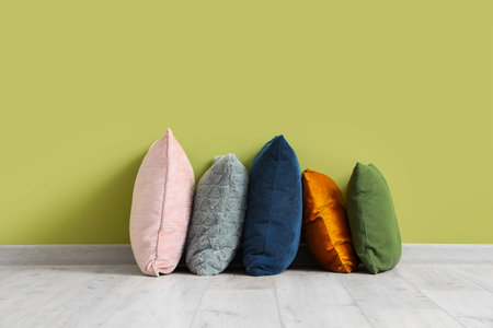 Soft pillows near green wall