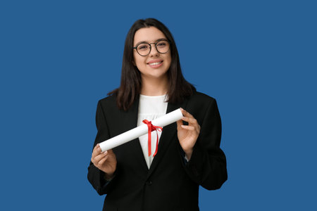 Happy smiling female student with diploma on blue background