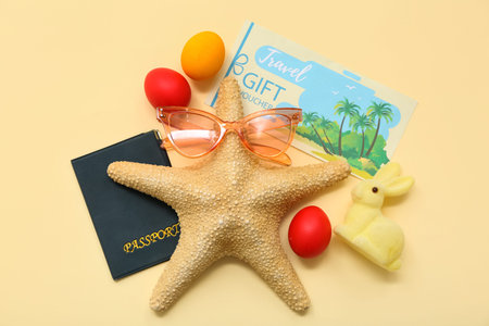 Sea star with sunglasses, passport and Easter decor on yellow background. Holiday travel composition