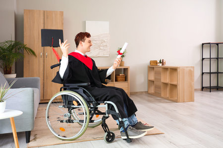 Male graduate in wheelchair with diploma at home